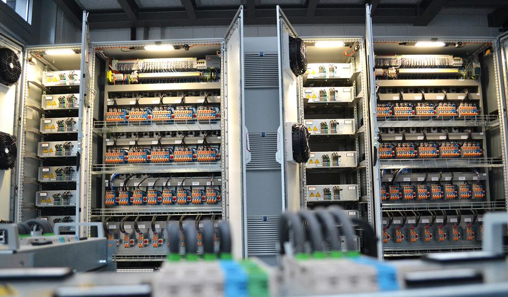 A hardware-in-the-loop testbench setup with terminals for routing cables to emulate grid networks.